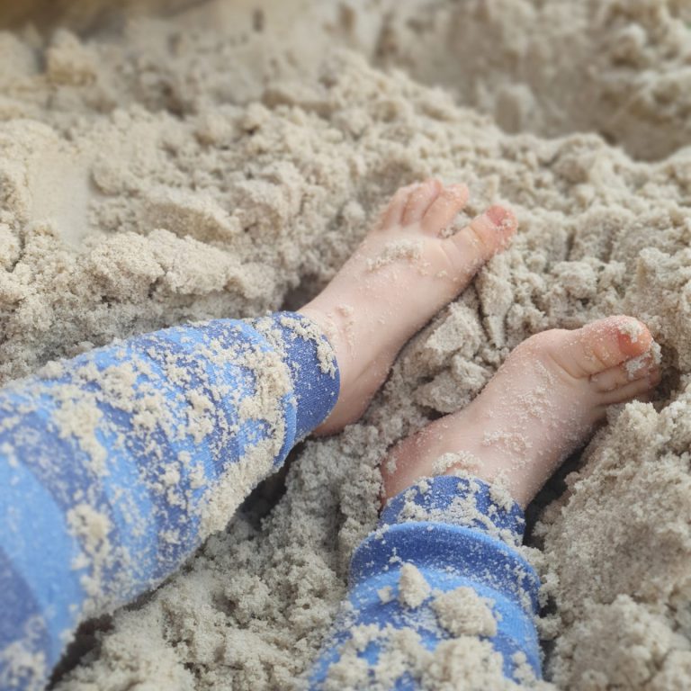 Kind mit Füßen im Sand