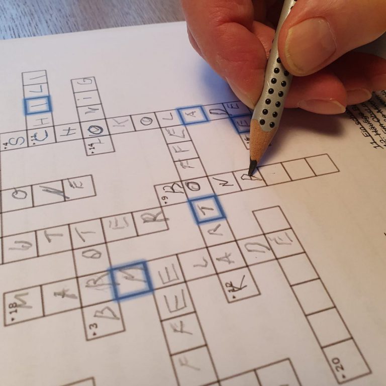 Hand beim Kreuzworträtsel lösen